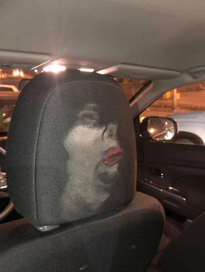 Cabeza de asiento de coche con mancha accidental que crea una imagen cómica de un rostro con labios rojos, comedia accidental.