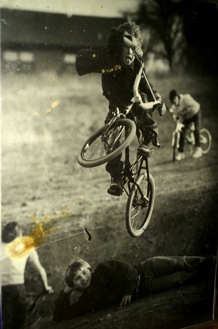 Niños en bicicletas realizando acrobacias en los años 80 mostrando la energía y libertad de la década salvaje.
