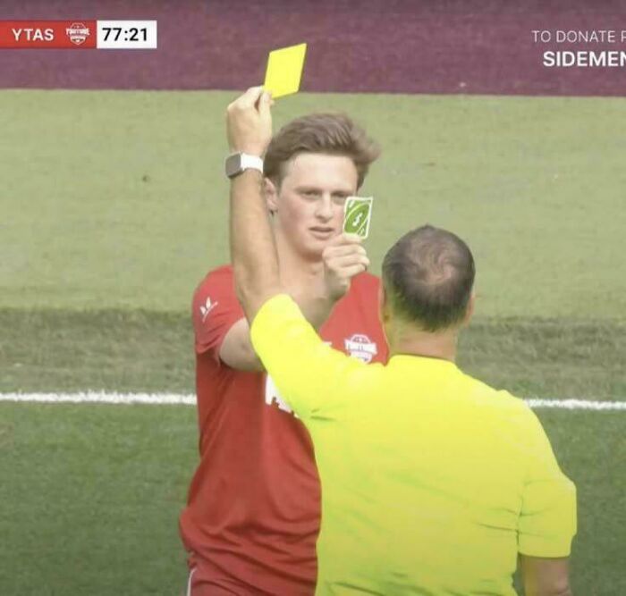 Jugador de fútbol recibiendo tarjeta amarilla durante un partido, imagen que provoca risas en grupo online dedicado a fotos que impactan.