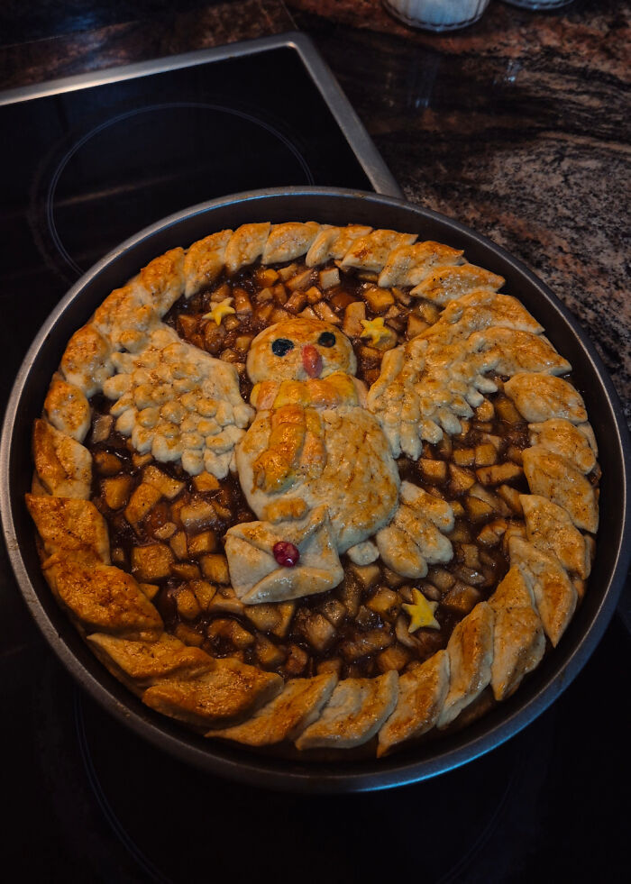 Tarta casera estilo cottagecore con diseño de búho, masa decorativa y relleno de manzana en cocina rústica acogedora.