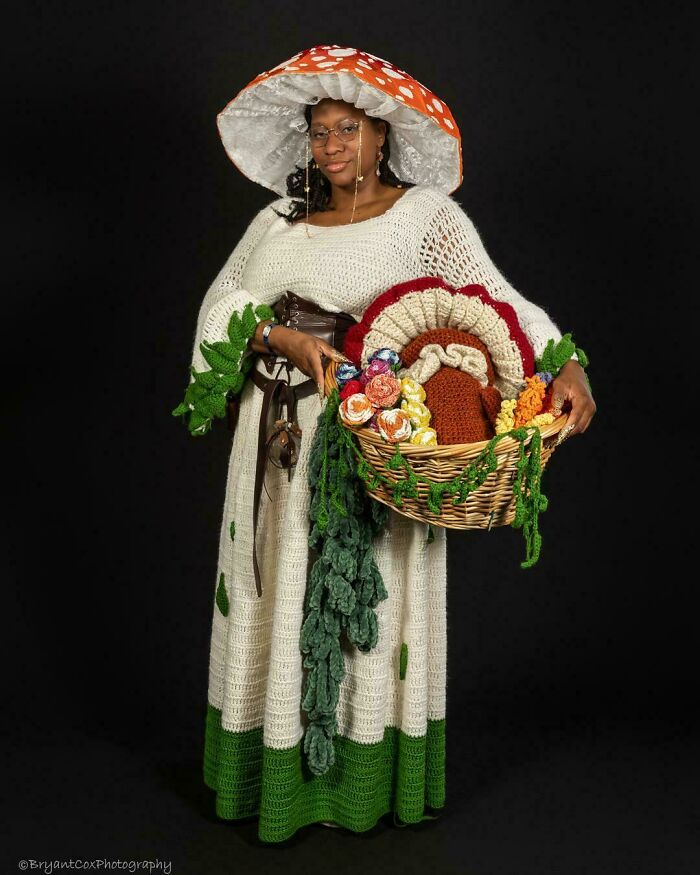 Mujer con vestido y sombrero estilo cottagecore, sosteniendo canasta con flores y decoraciones tejidas a mano.