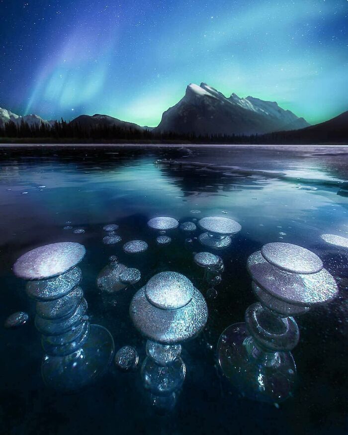 Burbujas de hielo congeladas y paisaje de montaña bajo luces boreales, foto de algo muy raro y aleatorio encontrado.