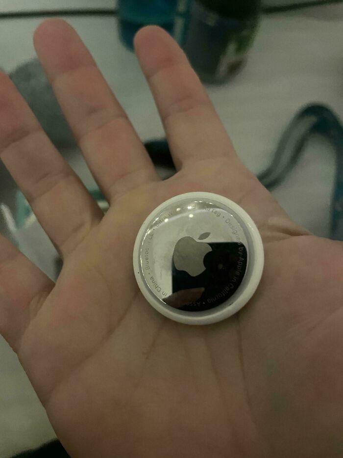 Mano sosteniendo un dispositivo Apple AirTag, ejemplo de objetos de personas que experimentaron cosas extrañas sin explicación.