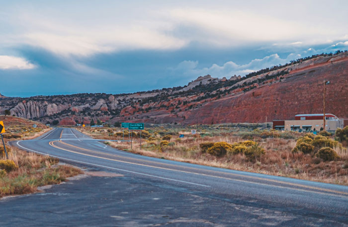 Carretera vacía en un paisaje árido con formaciones rocosas, representando lugares peor valorados por viajeros.