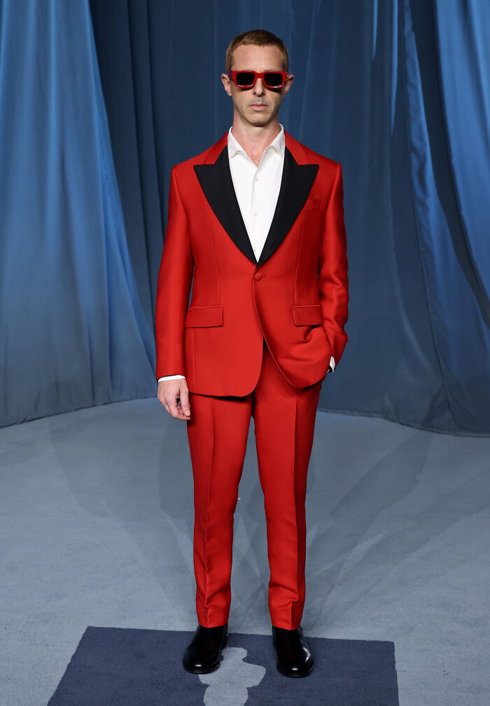 Hombre con traje rojo y gafas de sol en la alfombra de la moda en Academy Museum Gala 2025. Hombre con traje rojo y gafas de sol en la alfombra de la moda en Academy Museum Gala 2025.