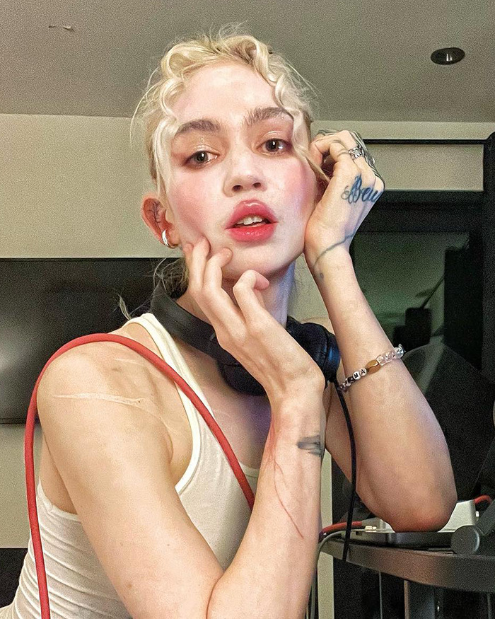 Persona rubia con camiseta blanca y audífonos, mostrando expresiones faciales en tendencia de celebridades que perdieron fanbases. Persona rubia con camiseta blanca y audífonos, mostrando expresiones faciales en tendencia de celebridades que perdieron fanbases.