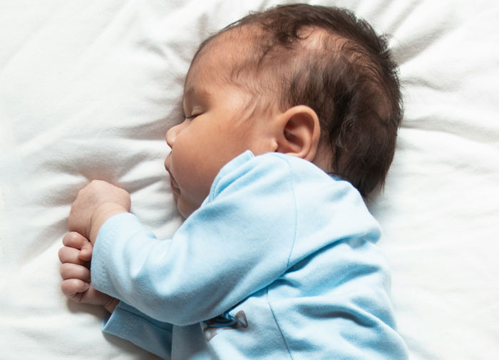 Bebé dormido en hospital, reflejando momentos de caos en salas de parto tras descubrir infidelidades.