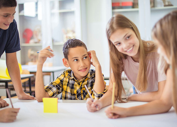 Niños en un aula interactuando mientras se observa caos y tensión relacionados con engaños y traiciones recientes.