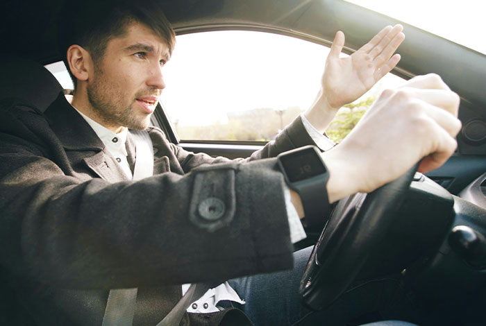 Hombre confundido y frustrado al volante, mostrando malinterpretación de señales sociales y situaciones incómodas legendarias.