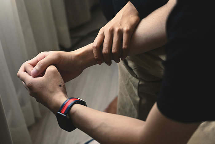 Pareja mostrando señales sociales confusas con manos entrelazadas en un momento de incomodidad y crímenes sociales.