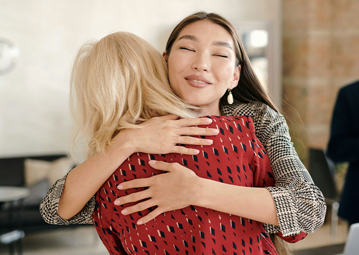 Dos mujeres abrazándose en señal de disculpa tras malinterpretar señales sociales creando momentos incómodos legendarios.