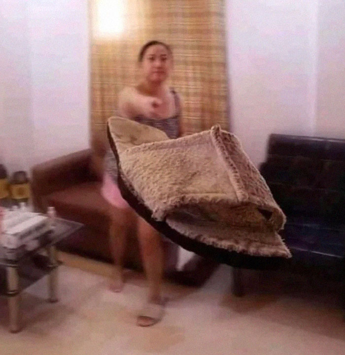 Persona lanzando una pantufla intentando capturar el momento antes de un desastre en una sala con muebles.