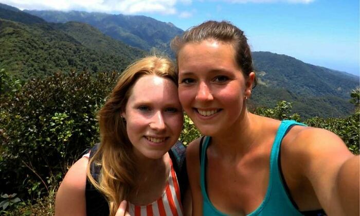 Dos mujeres sonrientes hacen selfie en un paisaje montañoso, relacionado con videos espeluznantes y found footage nocturno.