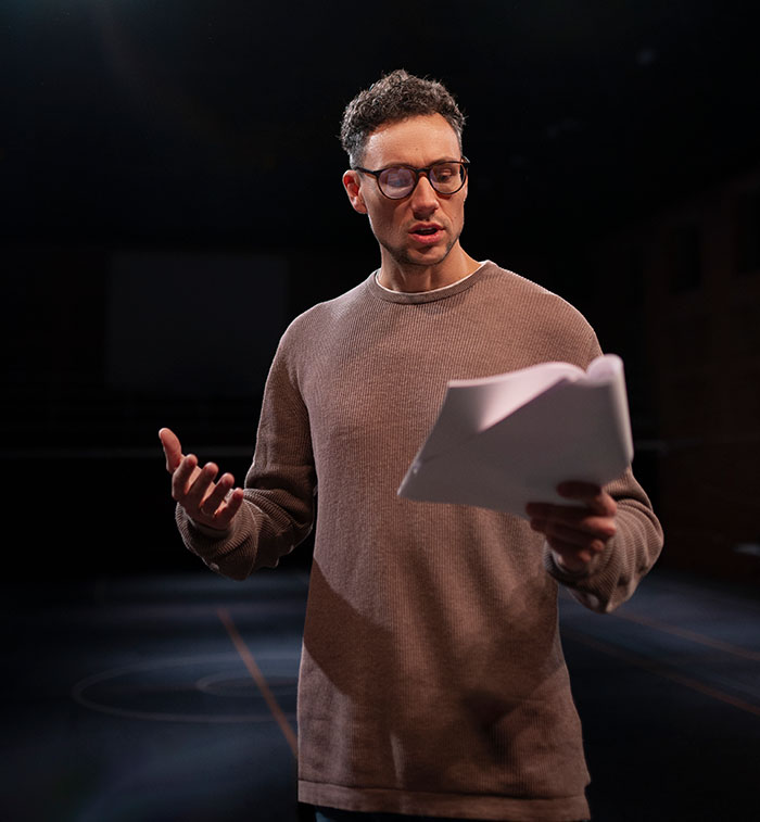 Hombre con gafas leyendo un guion, ilustrando las consecuencias que tuvo mentir en diferentes situaciones.