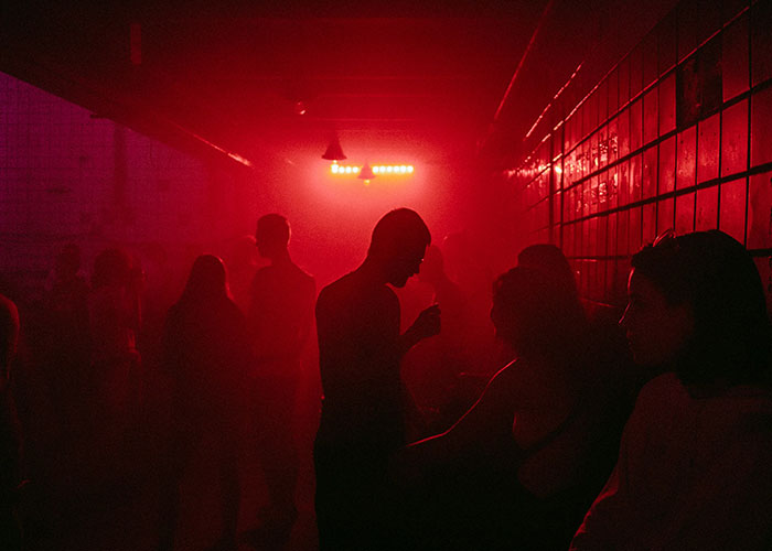 Personas en una habitación oscura con luz roja, ambiente dramático relacionado con hallazgos de médicos forenses. Personas en una habitación oscura con luz roja, ambiente dramático relacionado con hallazgos de médicos forenses.