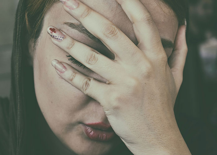 Mujer preocupada cubriéndose el rostro, ilustrando emociones ante hallazgos sorprendentes de médicos forenses en autopsias. Mujer preocupada cubriéndose el rostro, ilustrando emociones ante hallazgos sorprendentes de médicos forenses en autopsias.