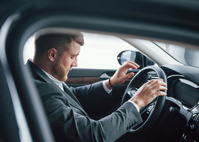 Hombre serio en traje sentado en auto, simbolizando sorprendentes hallazgos de médicos forenses durante autopsias. Hombre serio en traje sentado en auto, simbolizando sorprendentes hallazgos de médicos forenses durante autopsias.