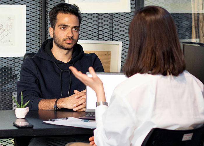 Hombre serio en entrevista conversando sobre momentos de karma instantáneo y consecuencias merecidas en la vida diaria.