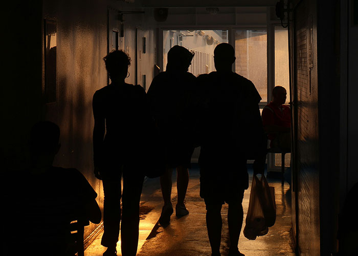 Sombras de personas caminando en un pasillo oscuro, ilustrando momentos de karma instantáneo y justicia.