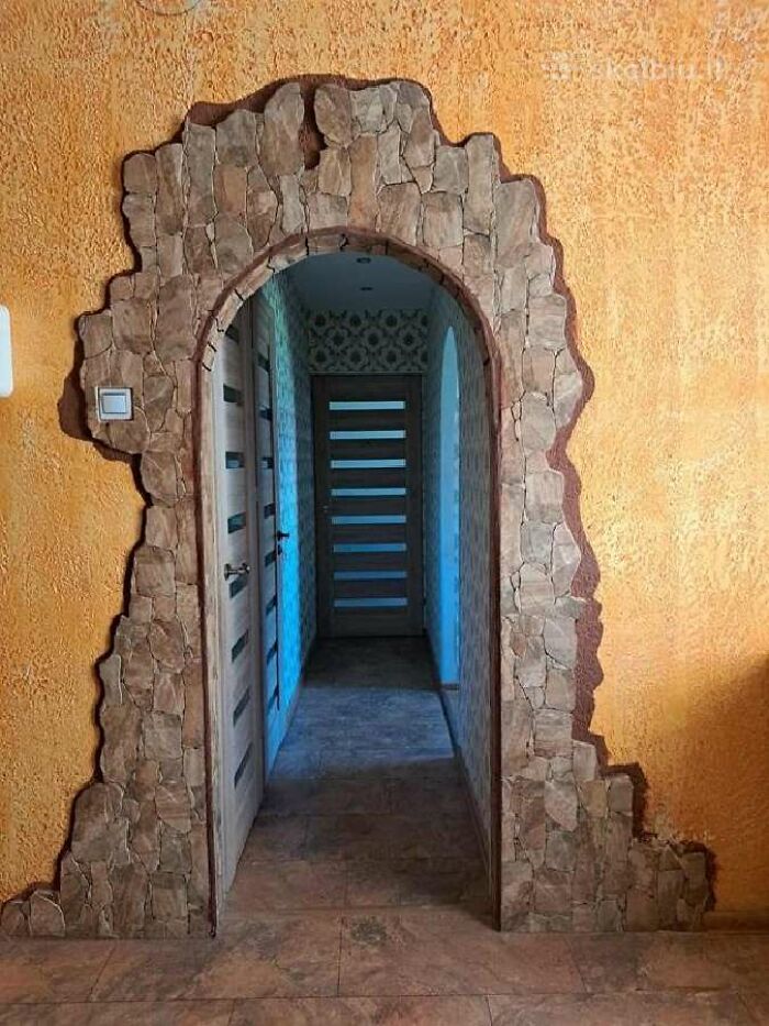 Entrada de vivienda con arco decorativo de piedra y paredes naranjas, listado inmobiliario entretenido destacado.