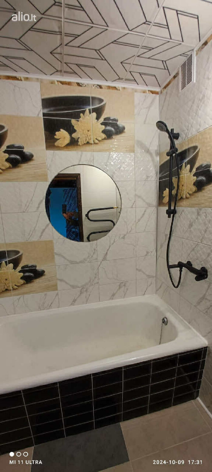 Baño con bañera y paredes decoradas con azulejos temáticos en listado entretenido de bienes raíces.