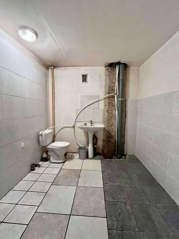 Baño con instalación deficiente y tuberías visibles en listado de bienes raíces entretenido y único.