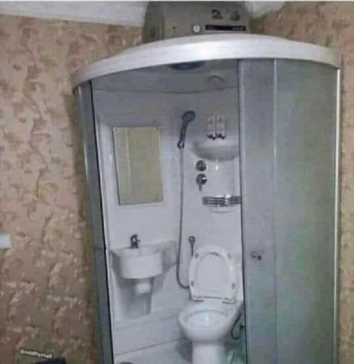 Baño compacto con ducha, lavabo e inodoro en un espacio pequeño, listado de Zillow con diseño extraño y poco funcional.