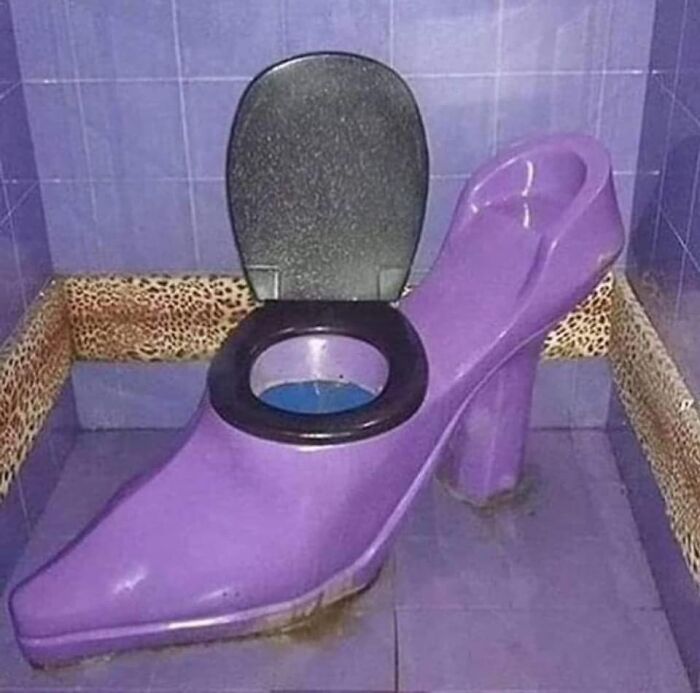 Inodoro en forma de zapato de tacón morado en baño con azulejos y bordes con diseño de leopardo, listado Zillow extraño.