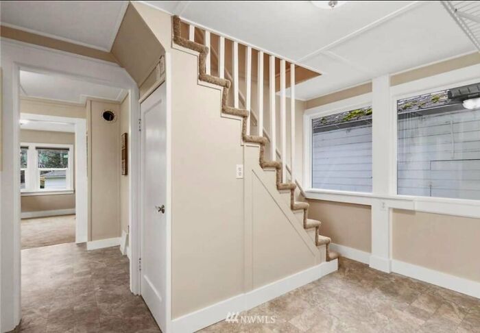Escalera con alfombra y ventana junto a diseño poco atractivo en listado de Zillow con apariencia rara y espacio incómodo.