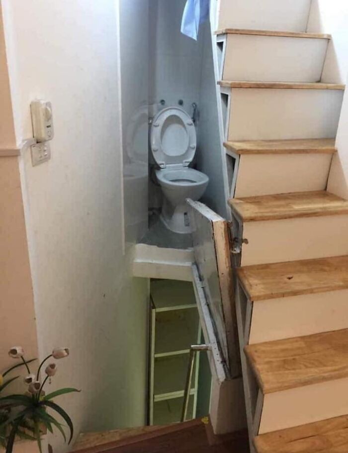 Baño mal ubicado debajo de escalera en listado de Zillow con diseños tan malos que parecen falsos.