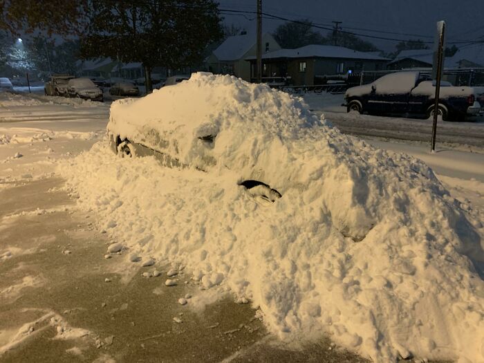 Coche cubierto completamente de nieve parado en la calle como ejemplo de venganza pequeña satisfactoria.