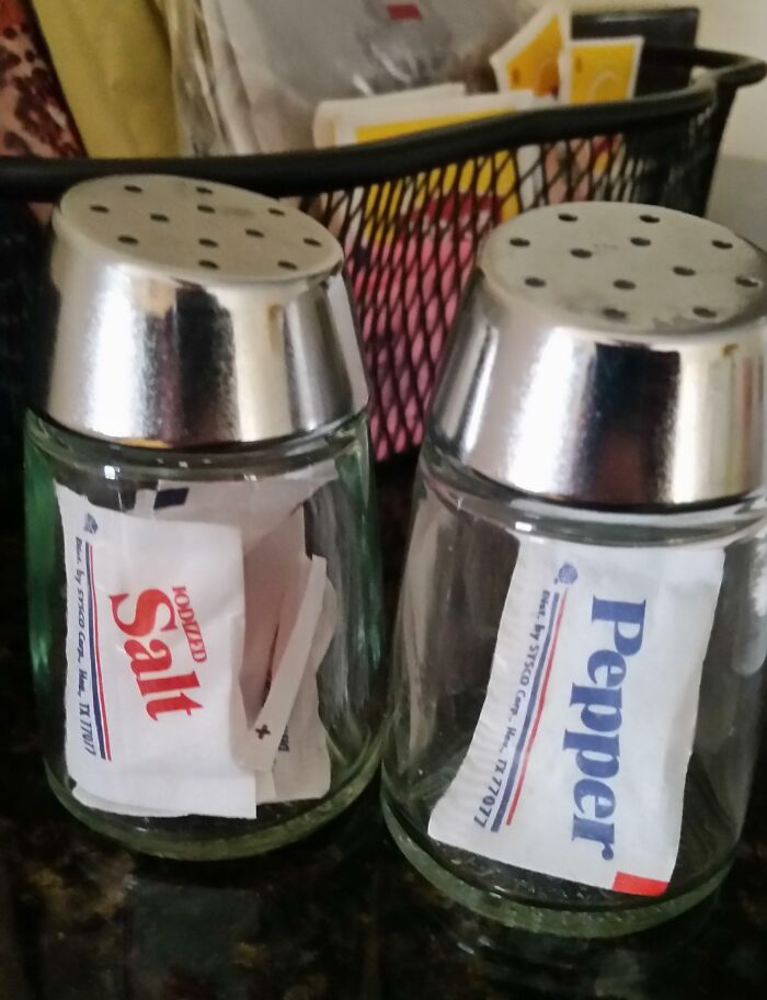 Salero y pimentero con sobres de sal y pimienta dentro, ejemplo divertido de fallos al seguir instrucciones literalmente.