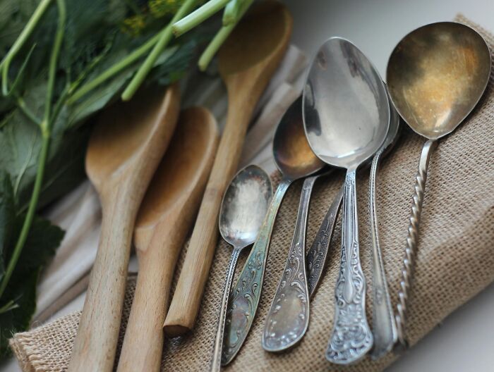 Utensilios de cocina de madera y metal organizados sobre tela, simbolizando la idea de venganza creativa contra ex parejas.