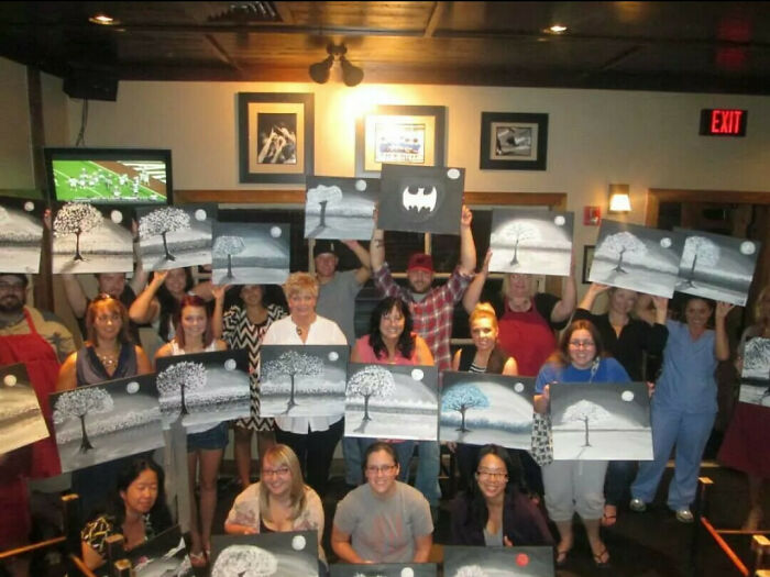 Grupo de adultos disfrutando de actividad artística mostrando cuadros, momentos divertidos de hombres que nunca crecieron.
