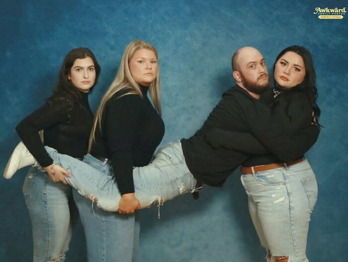 Cuatro personas posando en foto familiar fallida cargando a un hombre horizontalmente con fondo azul.
