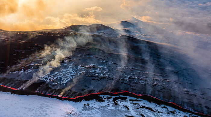Imagen impactante de naturaleza con lava fluyendo y humo visible, destacada en fotógrafo de naturaleza 2025.