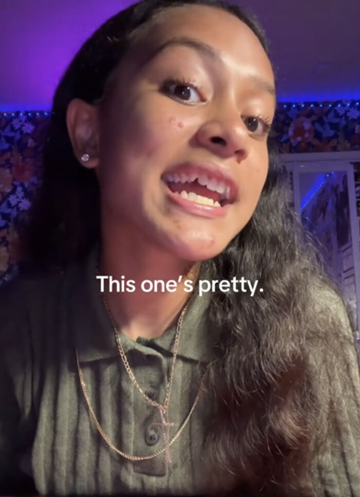 Joven celebrando lo que la hace única con expresión feliz y fondo iluminado con luces LED azul y decoración floral.