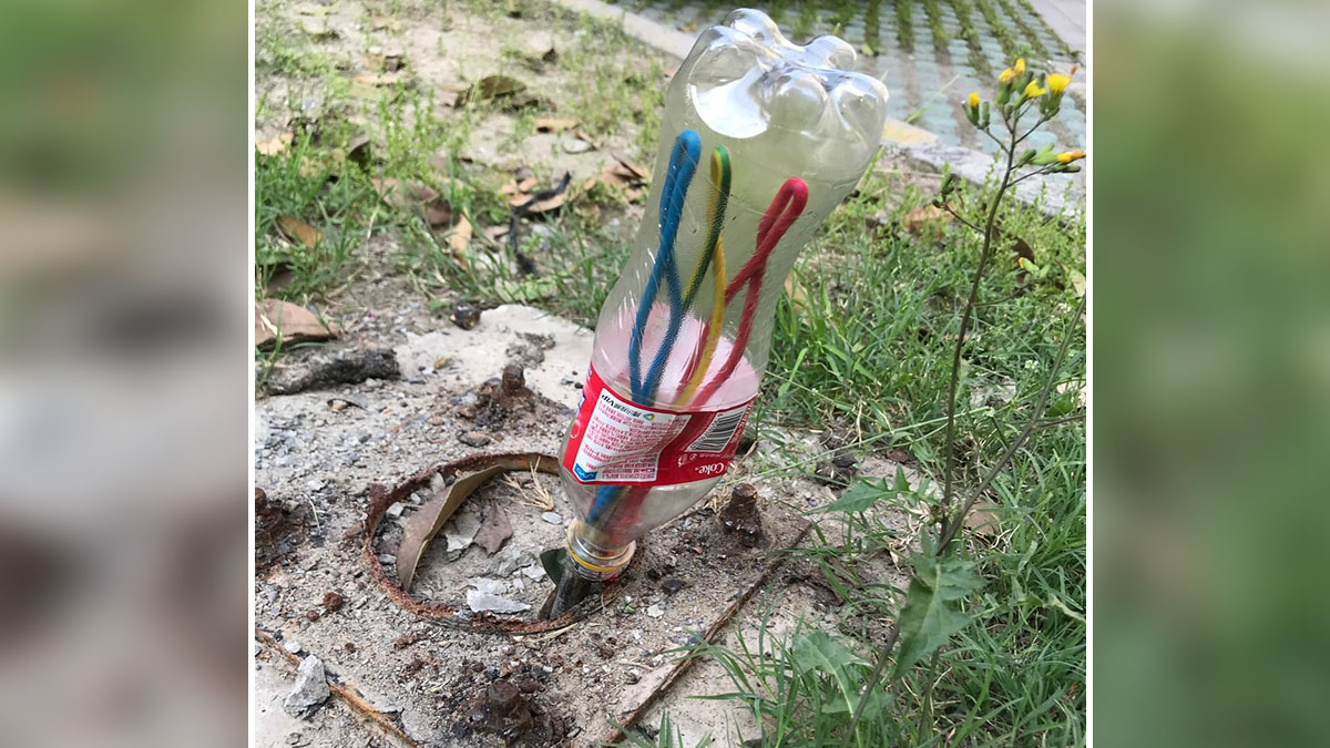 Botella de plu00e1stico con limpiapipas dentro en tierra, un error divertido de personas que siguieron instrucciones demasiado estrictas.