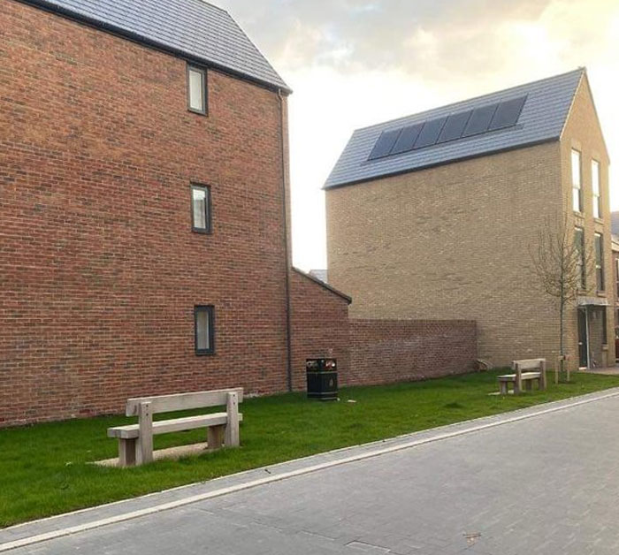 Bancos colocados delante de paredes, error de arquitectos y diseñadores en planificación urbana visible en calle residencial.