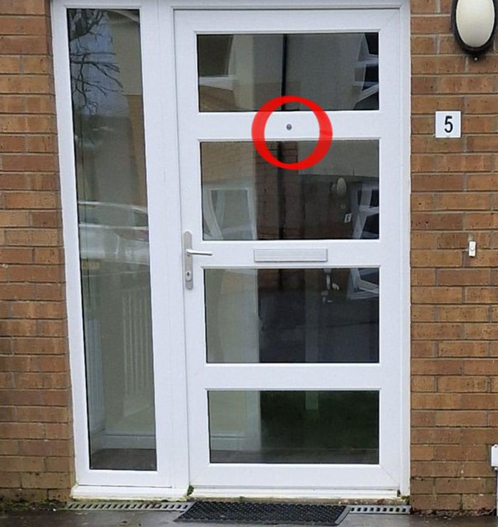 Puerta blanca con error de diseño señalado en círculo rojo, ejemplo de fallos de arquitectos, diseñadores y planificadores.