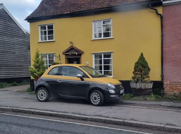Auto pintado para coincidir con diseño de fachada amarilla, ejemplo de error de arquitectos y diseñadores en planificación.