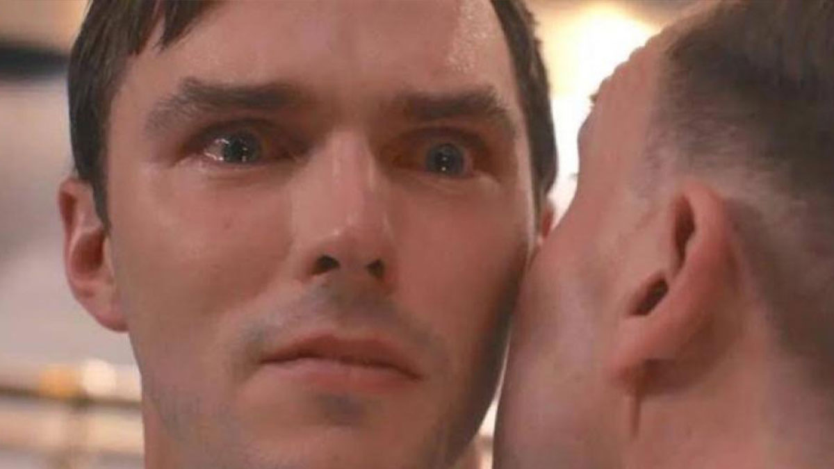 Primer plano de hombre con expresiu00f3n seria mientras otro susurra en su ou00eddo, meme aleatorio para reu00edr ru00e1pido.