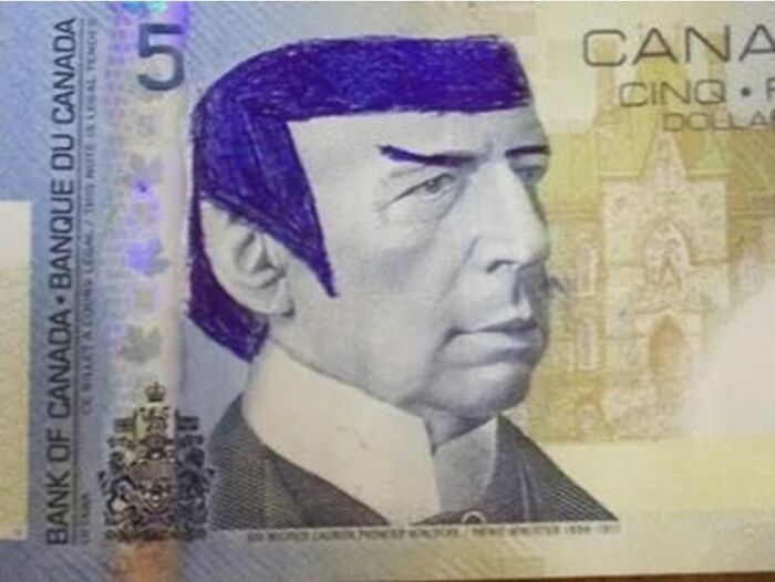 Billete de Canadá con dibujo en tinta azul de cabello y cejas, imagen que refleja temas extraños y polémicos.