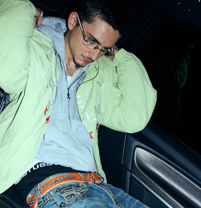 Joven con gafas y chaqueta verde en interior, relacionado con Timothée Chalamet y reacciones sobre Emma Thompson.