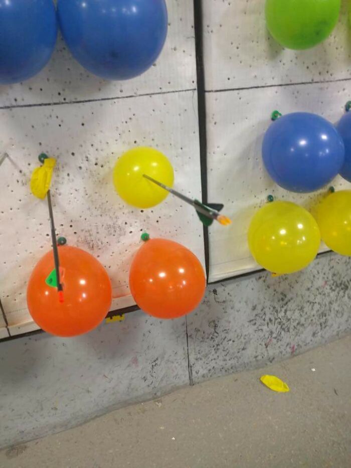 Globos de colores pinchados de manera inútil con flechas, ejemplo divertido de cosas inútiles que la gente encontró.