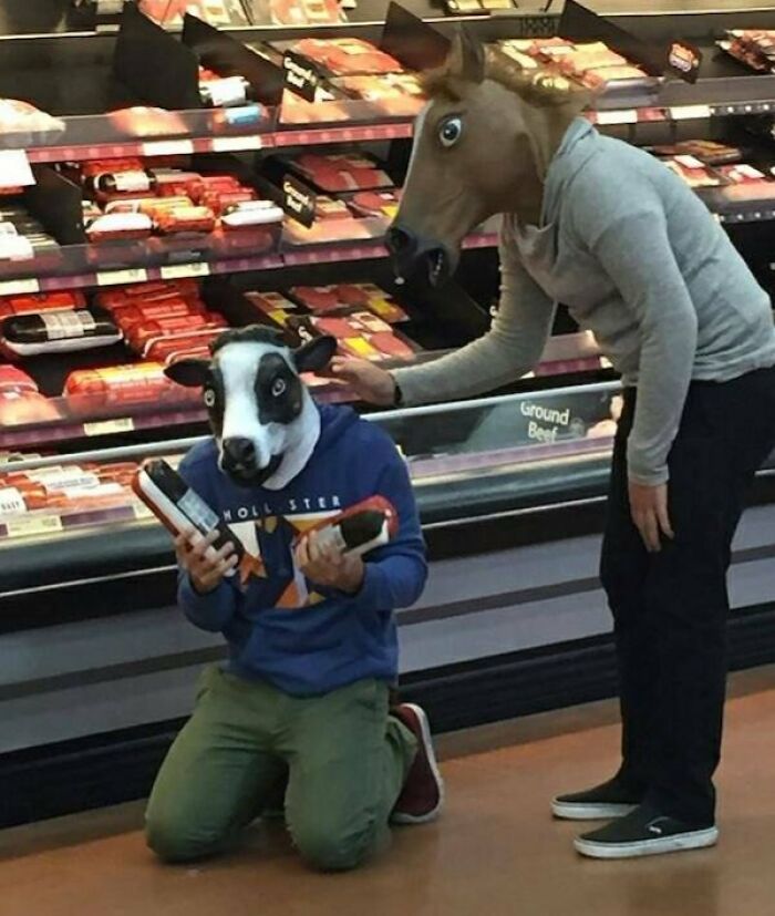 Personas en Walmart con máscaras de animales comprando carne en el supermercado, imagen curiosa y divertida.