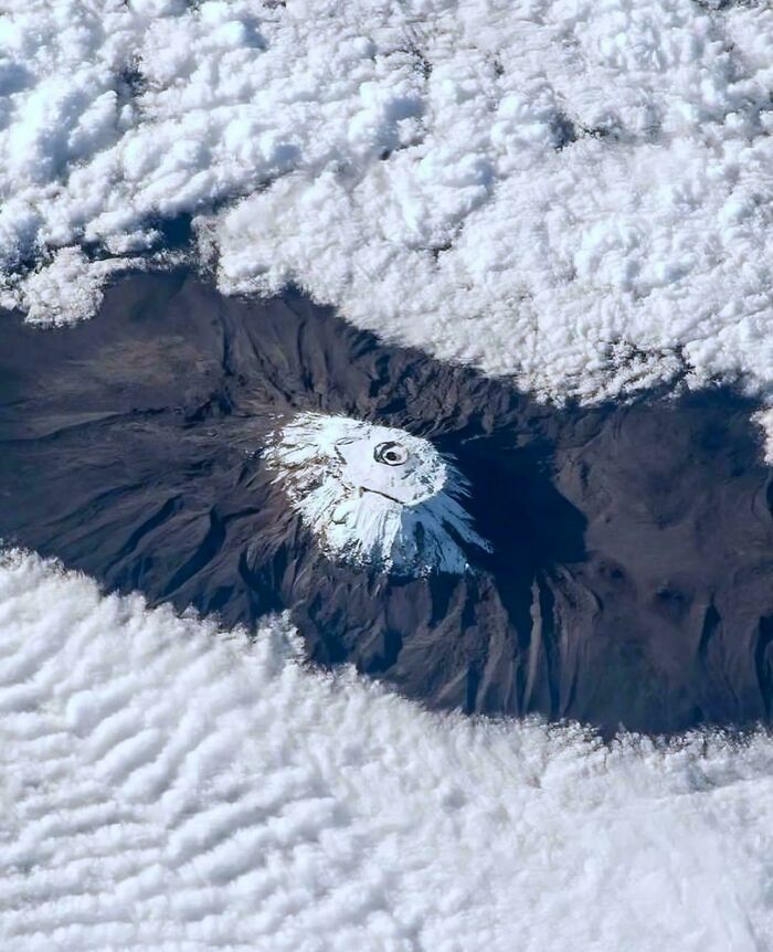 Imagen aérea de un volcán nevado rodeado de nubes, una de las cosas interesantes que la gente ha descubierto.
