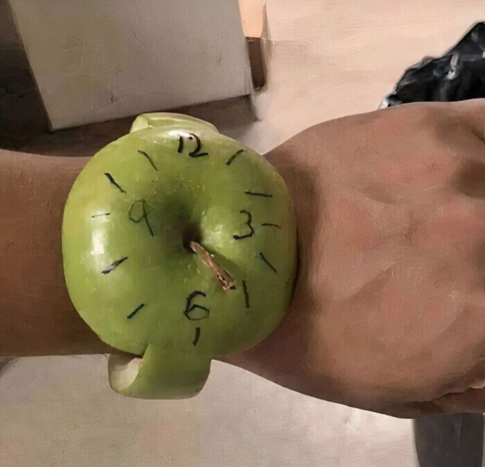Reloj casero hecho con una manzana verde en la muñeca, humor increíble divertido y creativo en imagen diaria.
