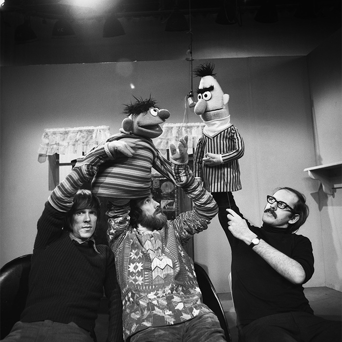 Foto impactante de cultura pop con personas manipulando marionetas clásicas en estudio televisivo antiguo.