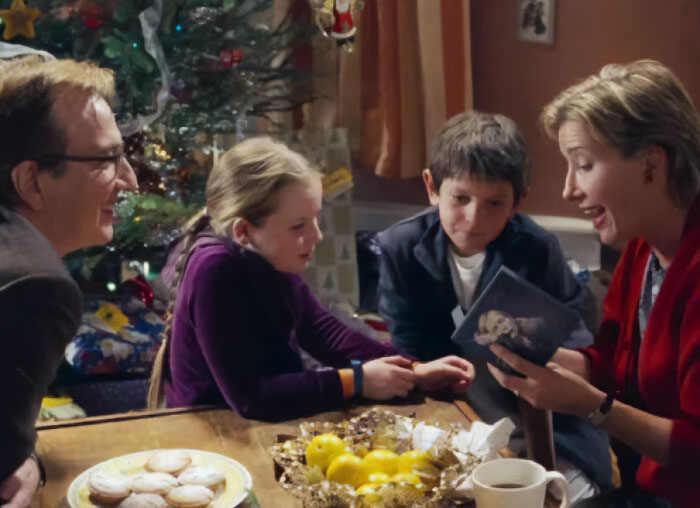 Familia reunida en Navidad, escena que evoca reacciones a Timothée Chalamet y mujeres corrigiendo a los chicos.